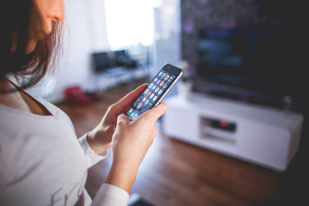 Woman using smartphone with apps open.