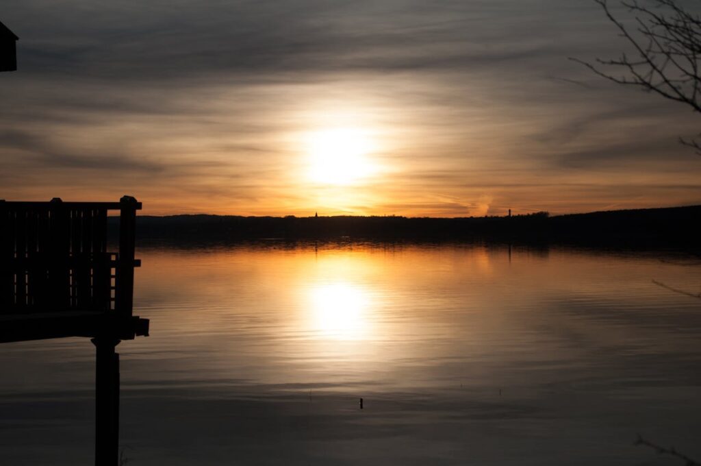 Sunset reflected in calm lake water.