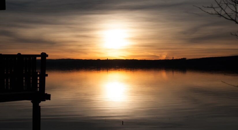 Sunset reflected in calm lake water.